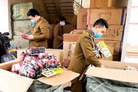 Lực lượng chức năng Cục Quản lý thị trường tỉnh Quảng Bình đang kiểm tra, xử lý vụ bắt giữ lô hàng giả, hàng nhập lậu. (Ảnh: TTXVN phát)