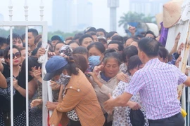 Người hâm mộ "phá rào" của lực lượng an ninh để tràn vào mua vé. (Ảnh: Minh Chiến/Vietnam+)