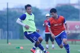 Công Phượng (áo cam) không gặp nhiều khó khăn khi đánh bại Mạc Hồng Quân ở bài đấu đối kháng. Tiền đạo của Hoàng Anh Gia Lai tỏ ra nhanh nhẹn hơn hẳn đàn anh. (Ảnh: Minh Chiến/Vietnam+)