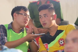 Keven Nguyễn (áo vàng) trao đổi với phóng viên VietnamPlus trong trận Hải Phòng - Bình Dương ở vòng 24 V-League. (Ảnh: Hiếu Lương/Vietnam+)