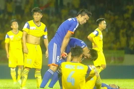 Quế Ngọc Hải (số 4) thất vọng gục xuống sân sau trận thua đầu tiên của Sông Lam Nghệ An trên đất khách mùa này. (Ảnh: Minh Chiến/Vietnam+)