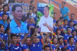 Những tấm ảnh tri ân huấn luyện viên Đinh Cao Nghĩa (áo xanh) và chủ tịch Phạm Thanh Hùng (áo trắng) được giăng trên sân Cẩm Phả chiều tối hôm qua (15/7). (Ảnh: Minh Chiến/Vietnam+)