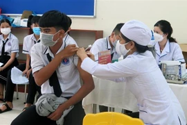 Nhân viên y tế tiêm vaccine phòng COVID-19 (mũi 3) cho học sinh tại thành phố Tuy Hòa, tỉnh Phú Yên. (Ảnh: Xuân Triệu/TTXVN)