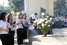 Thanh niên, sinh viên Kiều bào dâng hương tại mộ 10 Nữ Anh hùng Liệt sỹ Thanh niên Xung phong. (Ảnh: Công Tường/TTXVN)