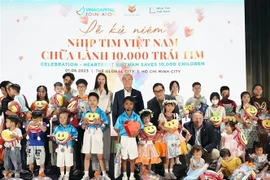 Đại diện VCF và nhà tài trợ tặng quà cho 30 em nhỏ được chương trình Nhịp tim Việt Nam hỗ trợ tại sự kiện. (Ảnh: Mỹ Phương/TTXVN)