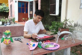 Anh Giang sáng tạo tranh bằng những vật liệu bỏ đi. (Ảnh: Thanh Thương/TTXVN)