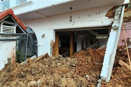 Một căn nhà bị đất đá vùi lấp tầng 1. (Ảnh: Chu Quốc Hùng/TTXVN)