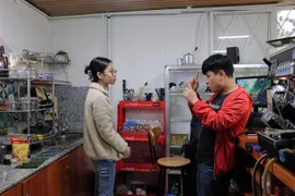 Nhân viên trong quán nói chuyện, trao đổi công việc với nhau bằng ngôn ngữ riêng. (Ảnh: Chu Quốc Hùng/TTXVN)