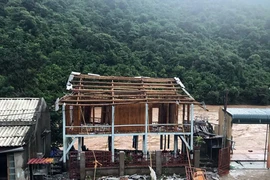 Lo sợ sạt lở nhà xuống sông, người dân bản Na Khà, xã Tén Tằn, huyện Mường Lát (Thanh Hóa) tháo nhà di dân. (Ảnh: TTXVN phát)