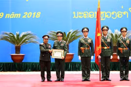 Thượng tướng Chansamone Chanyalath trao Huân chương Tự do Itxala của Nhà nước Lào cho Thượng tướng Phan Văn Giang. (Ảnh: Dương Giang/TTXVN)