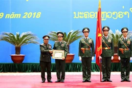 Thượng tướng Chansamone Chanyalath trao Huân chương Tự do Itxala của Nhà nước Lào cho Thượng tướng Phan Văn Giang. (Ảnh: Dương Giang/TTXVN)