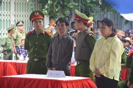 Bị cáo Nguyễn Hùng Dũng (áo đen) và bị cáo Lê Thị Phương Oanh (áo vàng) nghe tuyên án. (Ảnh: Đinh Văn Nhiều/TTXVN)