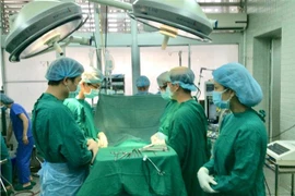 Các bác sỹ cúi đầu mặc niệm người hiến tạng. (Ảnh: TTXVN phát)