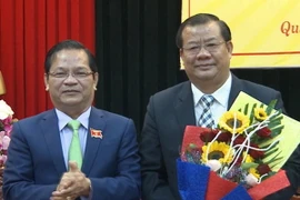 Bí thư Tỉnh ủy Quảng Ngãi Lê Viết Chữ (trái) tặng hoa chúc mừng tân Phó chủ tịch UBND tỉnh Nguyễn Tăng Bính. (Ảnh: Phước Ngọc/TTXVN)