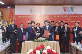 Phó Tổng giám đốc Đài Tiếng nói Việt Nam Vũ Hải và Giám đốc Đài Phát thanh Quốc gia Campuchia Tuan Sarath ký Thỏa thuận hợp tác. (Ảnh: Phương Hoa/TTXVN)