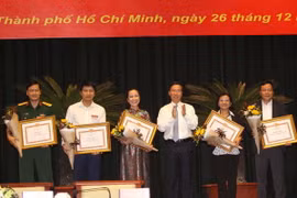 Đồng chí Võ Văn Thưởng, Ủy viên Bộ Chính trị, Bí thư Trung ương Đảng, Trưởng Ban Tuyên giáo Trung ương trao bằng khen cho các tập thể đạt thành tích trong năm 2017. (Ảnh: Thanh Vũ/TTXVN)