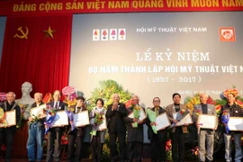 Đại diện Ban chấp hành Trung ương Hội mỹ thuật Việt Nam trao bằng khen cho các họa sỹ có thành tích xuất sắc góp phần xây dựng Hội mỹ thuật Việt Nam. (Ảnh: Thành Đạt/TTXVN)