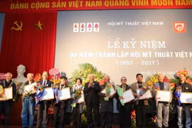 Đại diện Ban chấp hành Trung ương Hội mỹ thuật Việt Nam trao bằng khen cho các họa sỹ có thành tích xuất sắc góp phần xây dựng Hội mỹ thuật Việt Nam. (Ảnh: Thành Đạt/TTXVN)