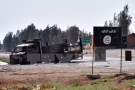 Cờ IS tại khu vực làng Dibsiafnan, ngoại ô Raqa, Syria ngày 11/6. (Nguồn: AFP/TTXVN)