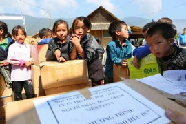 Học sinh trường Phổ thông Dân tộc bán trú Tiểu học và THCS Chế Tạo (xã Chế Tạo, huyện Mù Cang Chải) đón nhận những phần quà "Tủ sách Đinh Hữu Dư" của Đoàn thanh niên TTXVN trao tặng. (Ảnh: Thành Đạt/TTXVN)