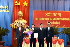 Phó Ban Tổ chức Trung ương Hà Ban, Bí thư Tỉnh ủy Hà Giang Triệu Tài Vinh và Bí thư Thứ nhất Trung ương Đoàn TNCS Hồ Chí Minh trao quyết định và tặng hoa chúc mừng Tân Phó Bí thư Tỉnh ủy Hà Giang Nguyễn Mạnh Dũng. (Ảnh: Minh Tâm/TTXVN.)