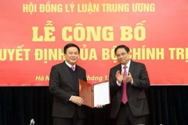 Đồng chí Phạm Minh Chính, Ủy viên Bộ Chính trị, Bí thư Trung ương Đảng, Trưởng ban Tổ chức Trung ương trao Quyết định của Bộ Chính trị và tặng hoa cho đồng chí Nguyễn Xuân Thắng. (Ảnh: Doãn Tấn/TTXVN)