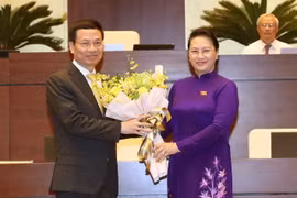 Chủ tịch Quốc hội Nguyễn Thị Kim Ngân tặng hoa chúc mừng ông Nguyễn Mạnh Hùng vừa được Quốc hội biểu quyết thông qua Nghị quyết phê chuẩn việc bổ nhiệm chức vụ Bộ trưởng Bộ Thông tin và Truyền thông. (Ảnh: Trọng Đức/TTXVN)