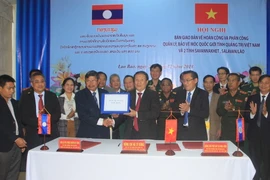 Lãnh đạo tỉnh Quảng Trị và tỉnh Salavan bàn giao hồ sơ bản vẽ hoàn công tại hội nghị. (Ảnh: Nguyên Lý/TTXVN)