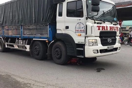 Chiếc xe máy nằm gọn trong gầm xe tải sau vụ tai nạn khiến 2 mẹ con tử vong. (Ảnh: Mạnh Linh/TTXVN)