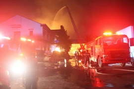 Lực lượng chữa cháy thị xã Tân Uyên đang dập lửa. (Ảnh: Nguyễn Văn Việt/TTXVN)