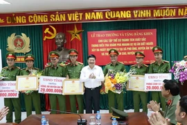 Chủ tịch Ủy ban Nhân dân tỉnh Hưng Yên Nguyễn Văn Phóng trao tiền thưởng và bằng khen cho đại diện các lực lượng phá án 2 vụ giết người. (Ảnh: Đinh Tuấn/TTXVN)