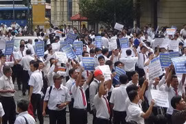 Hàng trăm tài xế taxi Vinasun cầm theo băngrôn, biểu ngữ đến dự phiên tòa hồi tháng 9/2018. (Ảnh: Thành Chung/TTXVN)