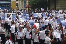Hàng trăm tài xế taxi Vinasun cầm theo băngrôn, biểu ngữ đến dự phiên tòa hồi tháng 9/2018. (Ảnh: Thành Chung/TTXVN)