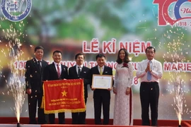 Tập thể sư phạm nhà trường vinh dự đón nhận Bằng khen của Bộ Giáo dục và Đào tạo và Cờ truyền thống của UBND Thành phố Hồ Chí Minh. (Ảnh: Thu Hoài/TTXVN)