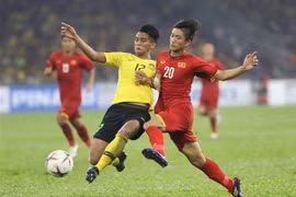 Phan Văn Đức tranh bóng với hậu vệ Malaysia. (Ảnh: Hoàng Linh/TTXVN)