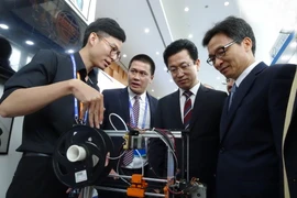 Phó Thủ tướng Vũ Đức Đam và Chủ tịch Hiệp hội WTA, ngài Her Tae Jeong xem các sản phẩm công nghệ tại hội chợ. (Ảnh: Nguyễn Huyền Trang/TTXVN)