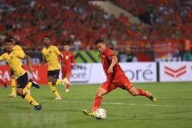 Cầu thủ của Việt Nam đột phá trong vòng vây của ba hậu vệ đội Malaysia. (Ảnh: Trọng Đạt/TTXVN)
