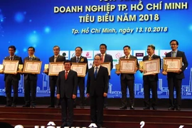 Ông Nguyễn Thiện Nhân, Ủy viên Bộ Chính trị, Bí thư Thành ủy Thành phố Hồ Chí Minh và ông Nguyễn Thành Phong, Chủ tịch Ủy ban Nhân dân Thành phố Hồ Chí Minh chúc mừng các doanh nghiệp tiêu biểu. (Ảnh: Xuân Anh/TTXVN)