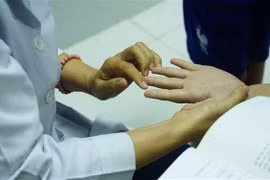 Khám bệnh cho trẻ em có dấu hiệu mắc bệnh tay chân miệng. (Ảnh: Đinh Hằng/TTXVN)
