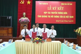 Ủy viên Trung ương Đảng, Tổng Giám đốc TTXVN Nguyễn Đức Lợi (phía trước, bên trái) và Ủy viên Trung ương Đảng, Bí thư Tỉnh ủy, Chủ tịch Hội đồng Nhân dân tỉnh Quảng Trị Nguyễn Văn Hùng (phía trước, bên phải) tại lễ ký. (Ảnh: Nguyên Lý/TTXVN)
