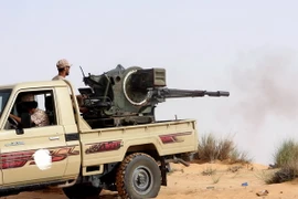 Các tay súng thuộc Bình minh Libya giao tranh với lực lượng trung thành với Chính phủ được quốc tế công nhận của Libya. (Ảnh: AFP/TTXVN)