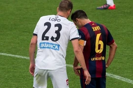 Trung vệ Alberto Lopo to nhỏ với Xavi trong trận đấu cuối cùng của La Liga. (Ảnh: Mundodeportivo.com)