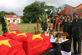 Lãnh đạo Bộ chỉ huy quân sự tỉnh An Giang thắp hương trước các hài cốt liệt sỹ chuẩn bị đưa về Việt Nam. (Ảnh:Vương Thoại TrungTTXV