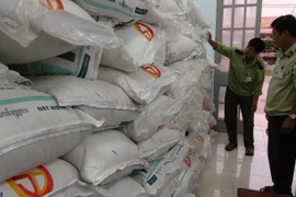 Cán bộ Đội quản lý thị trường kiểm kê lô hàng đường cát nhập lậu. (Ảnh: TTXVN)