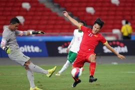 Pha tranh bóng giữa Mạc Hồng Quân với thủ môn U23 Indonesia. (Ảnh: Quốc Khánh/TTXVN)
