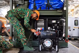 Bộ đội vận hành máy móc tẩy độc trong kho Rạng Đông. (Ảnh: Sơn Bách/Vietnam+) 
