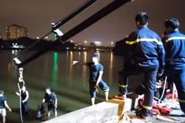 Cảnh sát tiến hành tìm kiếm và trục vớt chiếc xe (Ảnh: CTV T.Long/Vietnam+) 