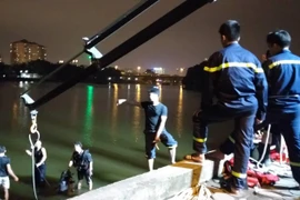 Cảnh sát tiến hành tìm kiếm và trục vớt chiếc xe (Ảnh: CTV T.Long/Vietnam+) 