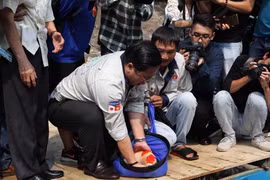 Chuẩn bị thả cá xuống sông Tô Lịch. (Ảnh: Sơn Bách/Vietnam+) 