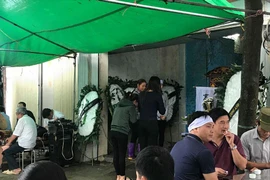 Những người tới chia buồn với V.A mang theo những vòng hoa tang trắng tinh khôi đầy ám ảnh (Ảnh: PV/Vietnam+) 